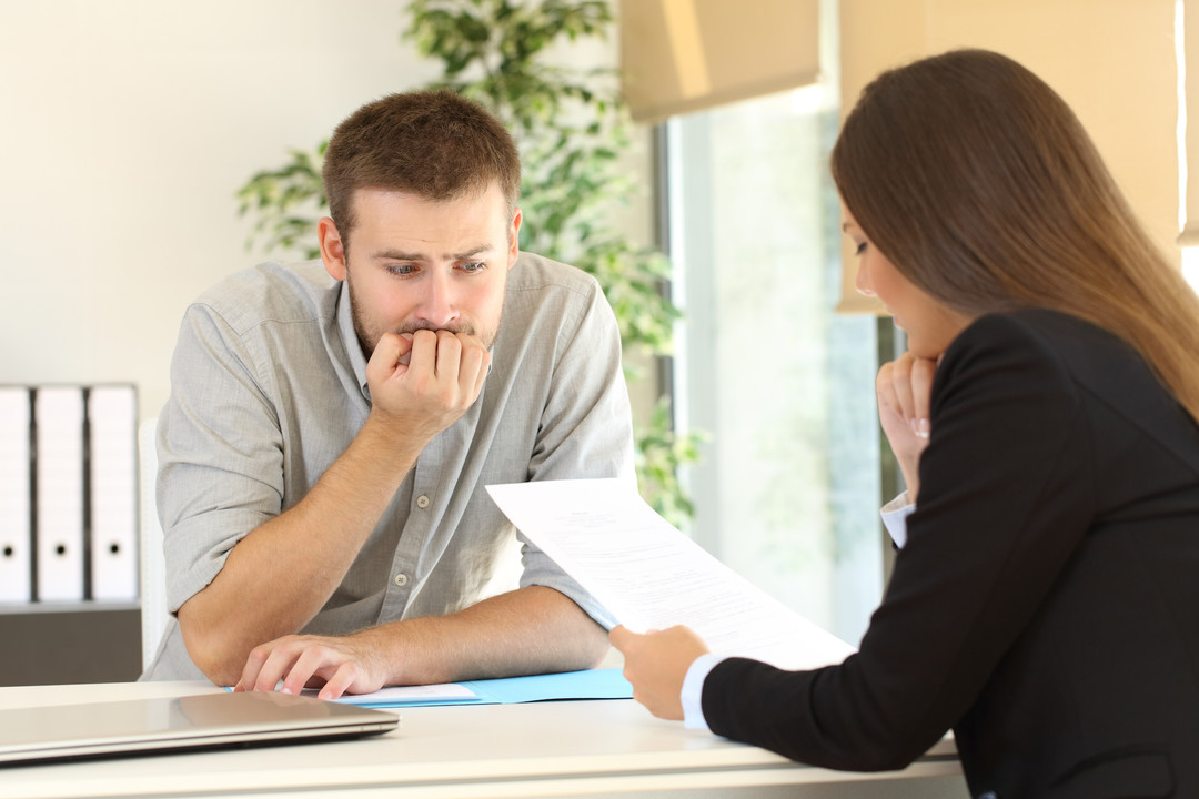 Illustration d’un candidat stressé face à un recruteur strict